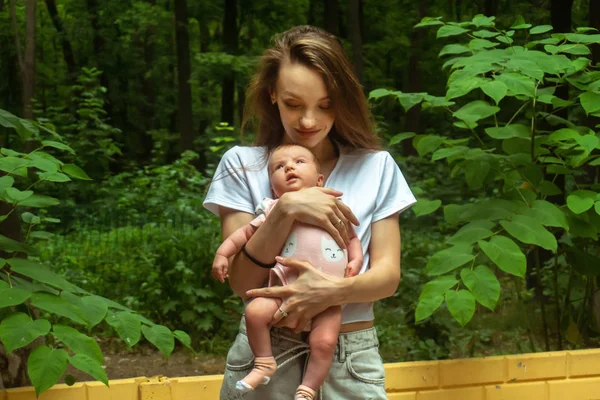 Encantadora madre joven con niña en las manos — Foto de Stock