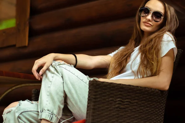 Sexy lady in sunglasses at the wooden house posing — Stock Photo, Image