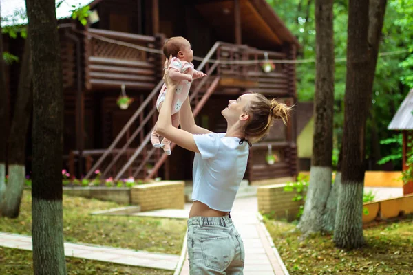 Madre joven con la pequeña hija en las manos — Foto de Stock