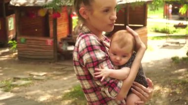 Kollarında bebekle genç bir anne.