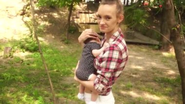 Kollarında bebekle genç bir anne.