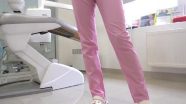 Klinikte pembe üniformalı dişçi.
