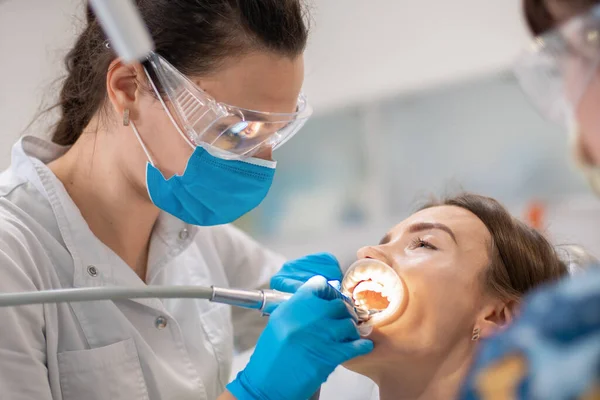 Οδοντίατρος και βοηθός θεραπεία των δοντιών ενός ασθενούς — Φωτογραφία Αρχείου