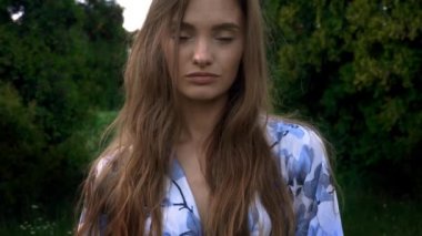 Güzel genç bayan kameraya bakıyor ve gülümsüyor.