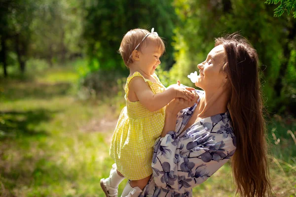 Charmante moeder hebben plezier met haar dochtertje in de tuin — Stockfoto