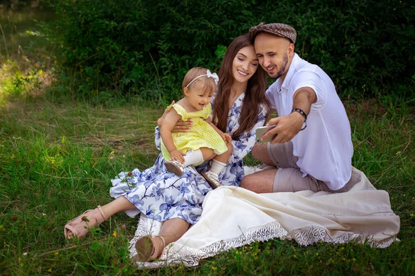 Schöne junge Familie macht Selfie beim Picknick — Stockfoto