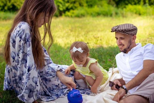 Πορτρέτο της ευτυχισμένης οικογένειας που διασκεδάζει στο πάρκο. Γονείς με την κόρη χαλάρωση στην ύπαιθρο. — Φωτογραφία Αρχείου
