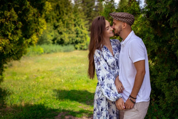 Pareja en el amor abrazos y sonrisas de la mano en el jardín verde —  Fotos de Stock