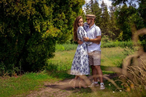 Пара закоханих тримає руки і дивиться один на одного в зеленому саду — стокове фото