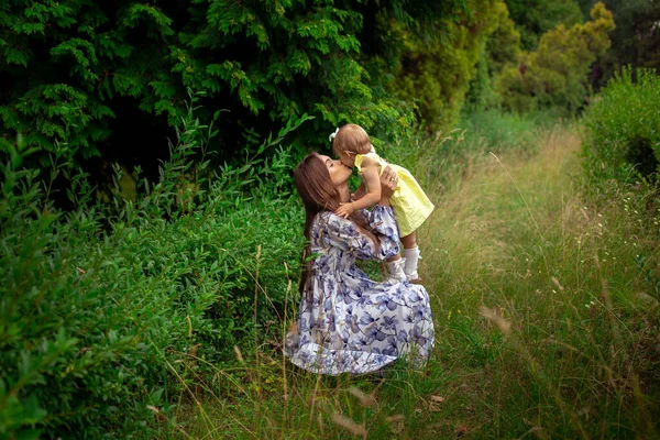 Gelukkig stijlvol moeder dragen haar kleine dochter buiten — Stockfoto
