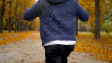 Genç bir çocuk sonbahar günü motosiklete biner.