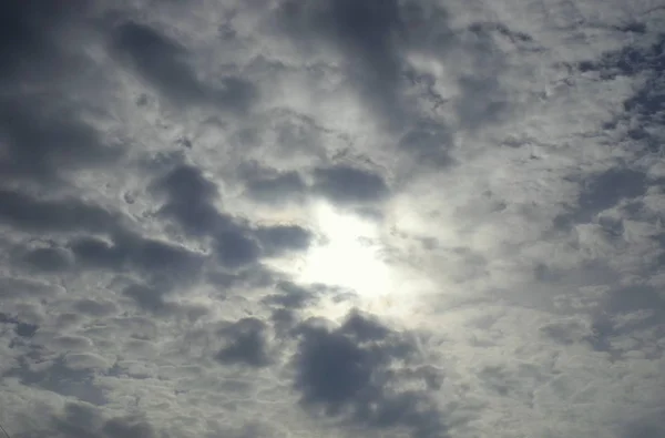 Gri bulutların arasından güneş ışığı, sonbahar gökyüzü