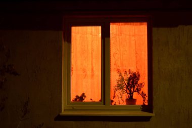 Geceleri bir evin penceresinden rahat ışık