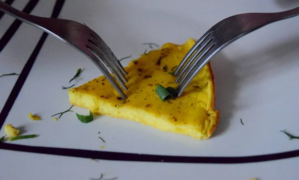 İki çatal çırpılmış yumurtanın son parçasını kaptı.