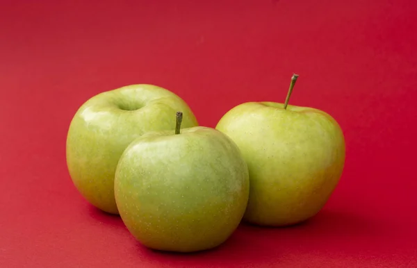Grüner Apfel auf rotem Hintergrund — Stockfoto