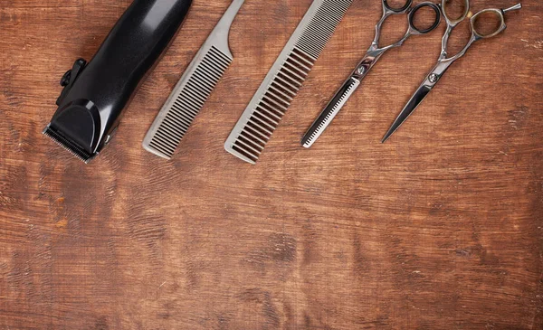 Herramientas para cortar cortes de pelo en peluquería sobre un fondo oscuro. Una maquinilla de afeitar peligrosa, una máquina de escribir, una cortadora de pelo . —  Fotos de Stock