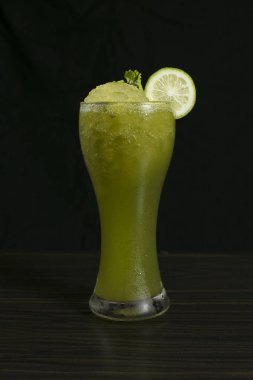 Parlak yeşil nane limonata kokteyl limon ve siyah arka plan üzerine nane yakılır