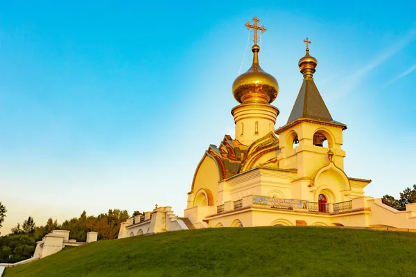 St. Seraphim Tapınağı Sarov Habarovsk şehir içinde güzel manzara günbatımı sırasında. Güzel bir yeşil çim ön planda. Dini mimari, binalar ve gelenekleri. Rusya.