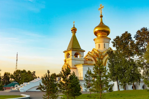 St. Seraphim Tapınağı Sarov Habarovsk şehir içinde güzel manzara günbatımı sırasında. Güzel bir yeşil çim ön planda. Dini mimari, binalar ve gelenekleri. Rusya.