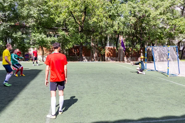男子在绿色人造草皮上玩迷你足球 — 图库照片