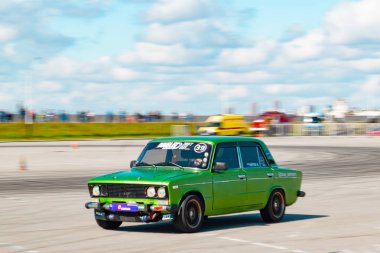 Rus üretimi parlak yeşil renkli araba yüksek hızda sürüklenir