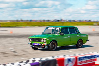 Rus üretimi parlak yeşil renkli araba yüksek hızda sürüklenir