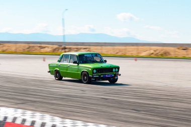 Rus üretimi parlak yeşil renkli araba yüksek hızda sürüklenir