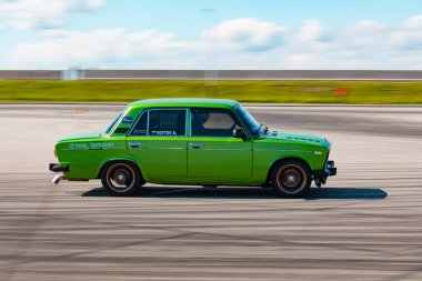 Rus üretimi parlak yeşil renkli araba yüksek hızda sürüklenir