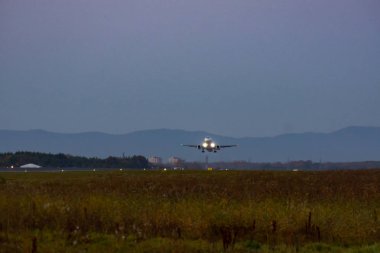 Uçak yüksek hızda şafakta çıkartıyor. Pist fotoğraf. Havaalanı Khabarovsk-Novy Uhhh, Rusya. Sukhoi Superjet 100-95b.
