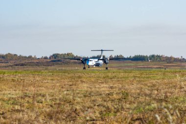 Uçak piste, gündoğumu, yüksek hızda iner. Havaalanı Khabarovsk-Novy Uhhh, Rusya. Bombardier Dash 8 Q400.