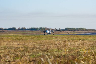 Uçak piste, gündoğumu, yüksek hızda iner. Havaalanı Khabarovsk-Novy Uhhh, Rusya. Bombardier Dash 8 Q400.