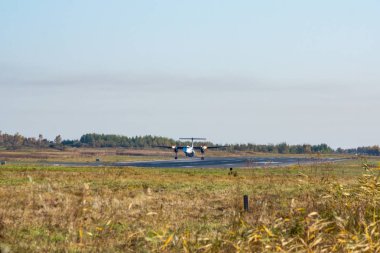 Uçak piste, gündoğumu, yüksek hızda iner. Havaalanı Khabarovsk-Novy Uhhh, Rusya. Bombardier Dash 8 Q400.
