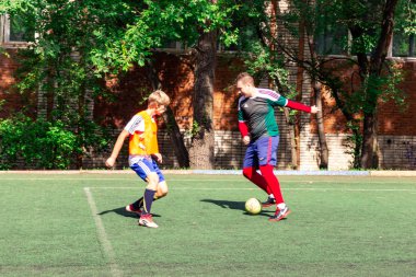 Rusya, Khabarovsk - 25 Ağustos 2018: sokak yerli oynarken futbol. Genç çocuklar futbol yeşil çimenlerin üzerinde oynamak.