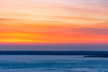 Güzel gün batımı Khabarovsk Amur Nehri üzerinde. Kış. Donmuş nehir. İnsanlar buz üzerinde yürümek.