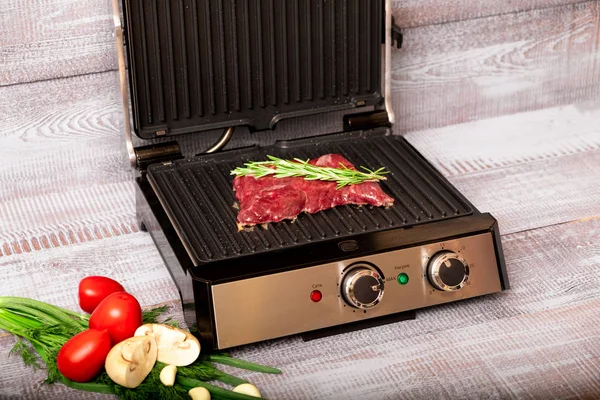 Beef steak with vegetables. Preparation on electric grill — Stock Photo, Image