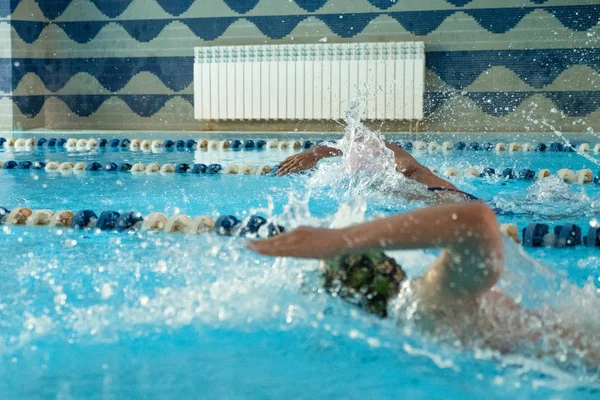 Gyerekek úszkálnak szabadon. Fedett medence tiszta kék vízzel. — Stock Fotó