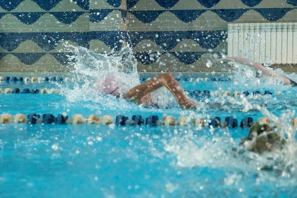 Gyerekek úszkálnak szabadon. Fedett medence tiszta kék vízzel. — Stock Fotó