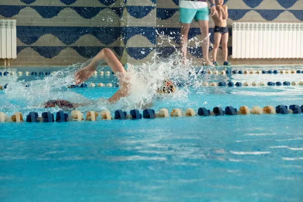 Crianças nadando estilo livre. Piscina interior com água azul clara. — Fotografia de Stock