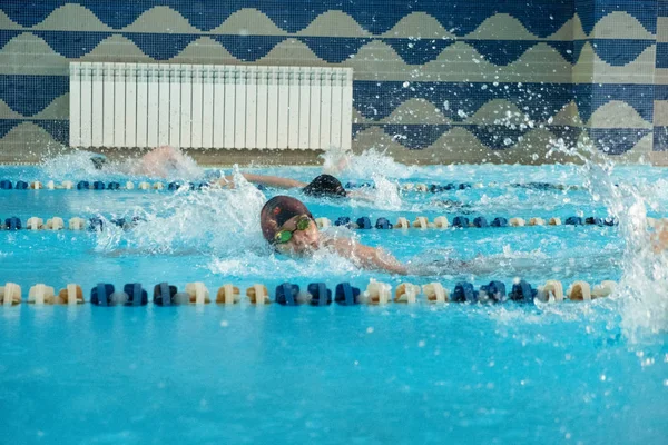 Crianças nadando estilo livre. Piscina interior com água azul clara. — Fotografia de Stock