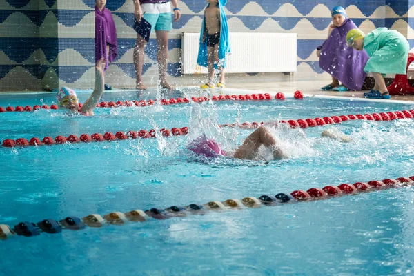 Khabarovsk, Rusia - 19 de mayo de 2019: niños nadando estilo libre. Piscina cubierta con agua azul clara . —  Fotos de Stock