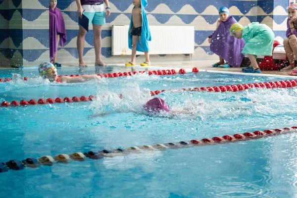 Khabarovsk, Rusia - 19 de mayo de 2019: niños nadando estilo libre. Piscina cubierta con agua azul clara . —  Fotos de Stock