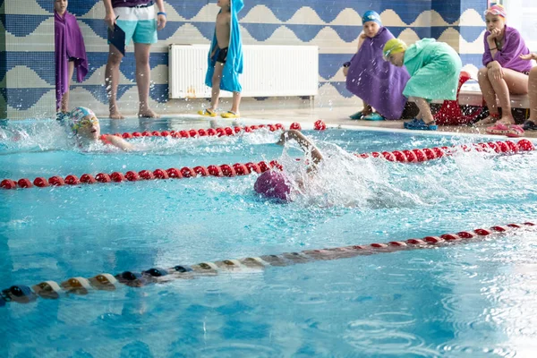 Khabarovsk, Rússia - 19 de maio de 2019: crianças nadando livre. Piscina interior com água azul clara . — Fotografia de Stock