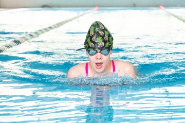 Khabarovsk, Rusya - 19 Mayıs 2019: Kurbağalama da yüzen çocuklar. Berrak mavi su ile kapalı yüzme havuzu.