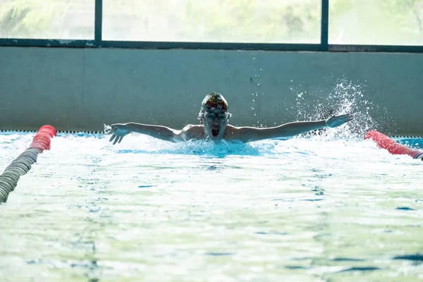 俄罗斯哈巴罗夫斯克 - 2019年5月19日：儿童游泳蝴蝶。带清澈蓝色水的室内游泳池. — 图库照片