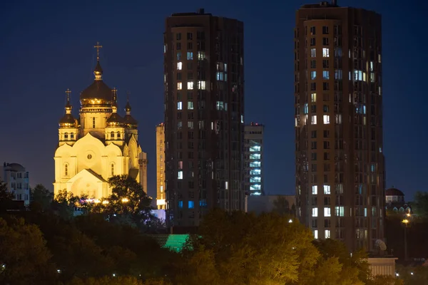 Vista noturna da cidade de Khabarovsk do rio Amur. Céu azul noturno. A cidade noturna é iluminada com lanternas. — Fotografia de Stock