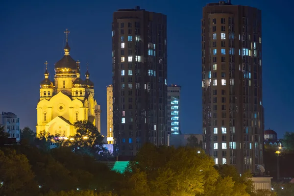 Vista noturna da cidade de Khabarovsk do rio Amur. Céu azul noturno. A cidade noturna é iluminada com lanternas. — Fotografia de Stock