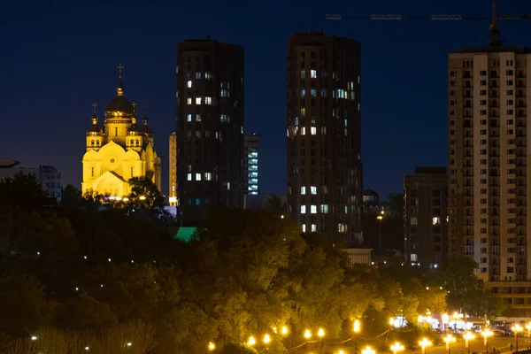 Vista noturna da cidade de Khabarovsk do rio Amur. Céu azul noturno. A cidade noturna é iluminada com lanternas. — Fotografia de Stock
