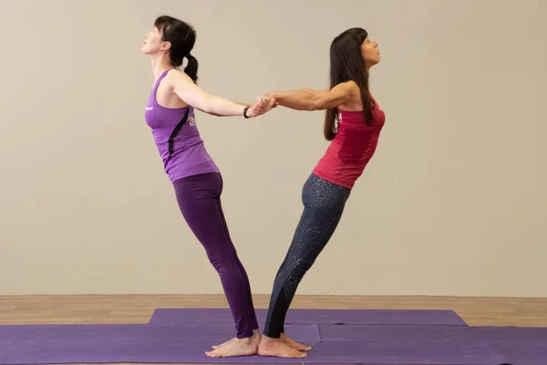 KHABAROVSK, RUSSIA - APR 18, 2019: A group of young sports people practicing yoga lesson with an instructor. Fitness club instructors show a master class. Sporty young girls. — Stock Photo, Image