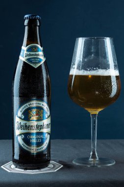 Khabarovsk, Rusya - 21 Temmuz 2018: bira şişesi Weihenstephan ve mavi arka plan üzerinde masada bir bardak bira