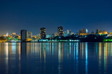 Amur Nehri 'nden Khabarovsk şehrinin Gece Manzarası. Mavi gece gökyüzü. Gece şehri fenerlerle parıldıyor..